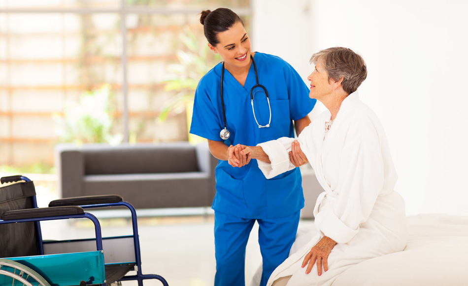 Home nurse helping woman stand up